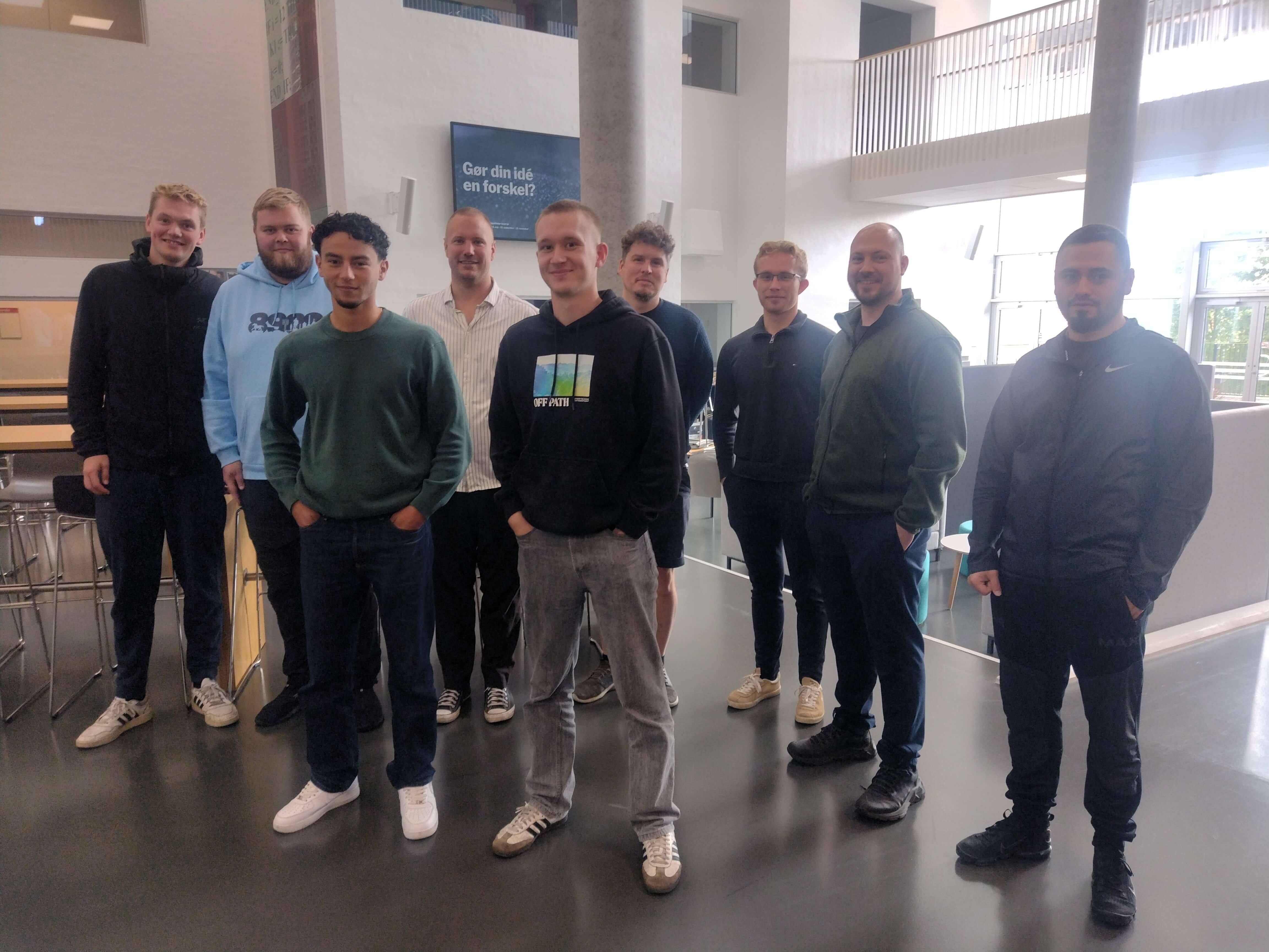 en gruppe el-installatørstuderende står sammen med projektchef Troels i kantinen på campus Randers