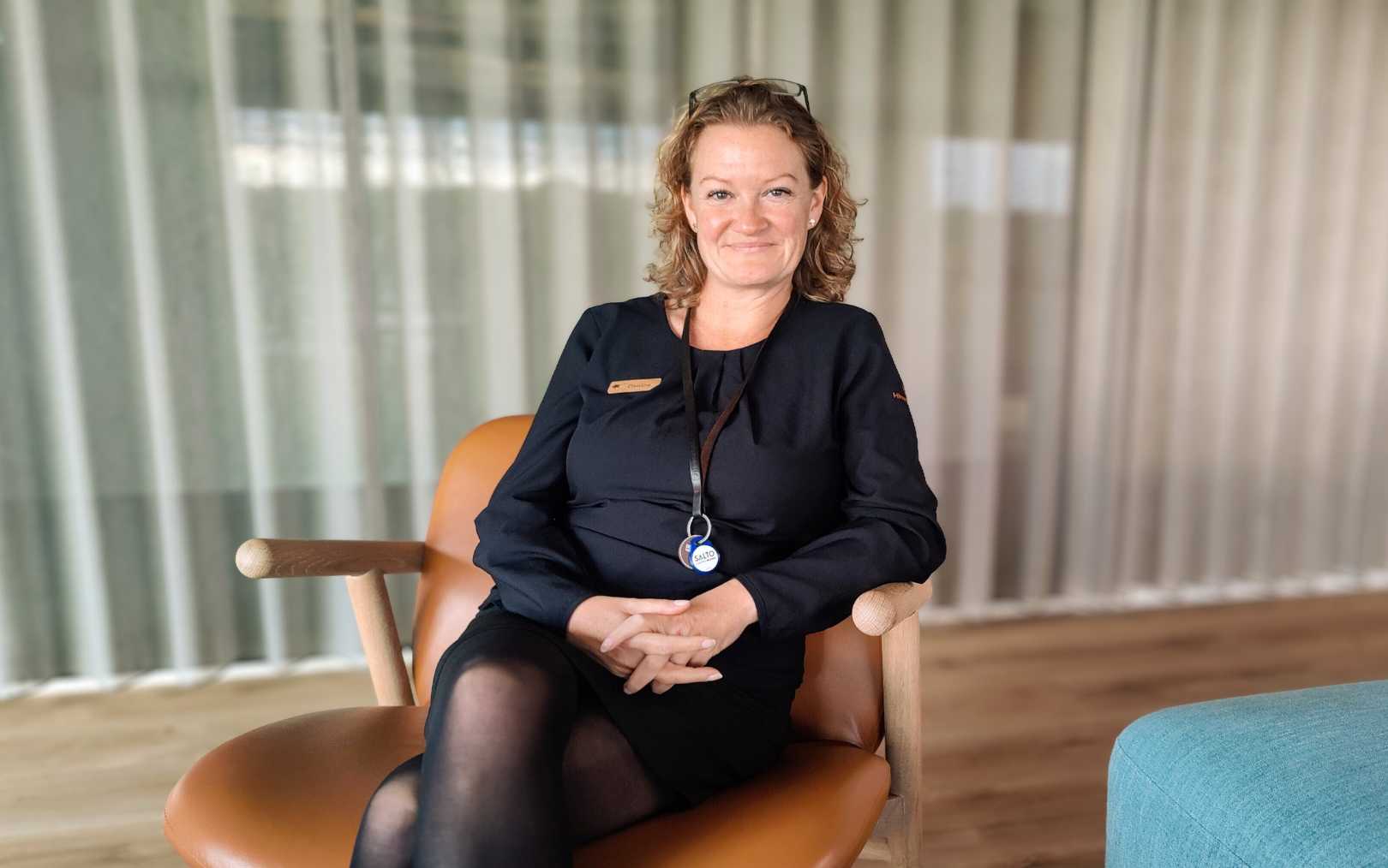 Christine, der har taget efteruddannelse på Erhvervsakademi Dania, sidder i en stol og kigger på dig 