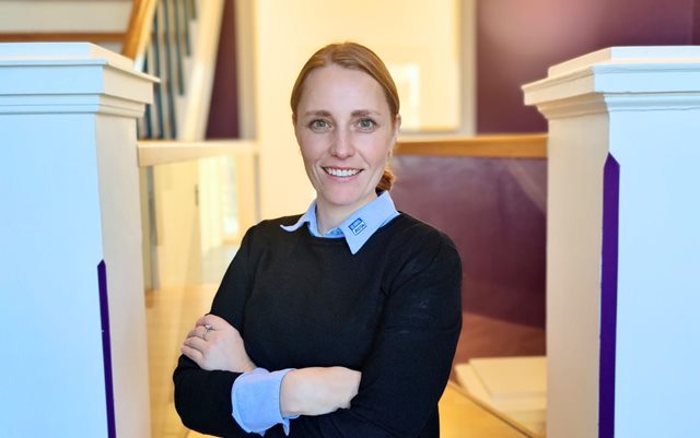 Louise fra Bila, der har været på leder uddannelse via Erhvervsakademi Dania, står med armene over kors i gangen