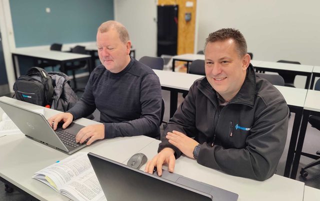 Joakim, der læser drift og automation på Erhvervsakademi Dania, hvilket er det samme som en automationsteknolog-uddannelse på deltid, sidder ved sin computer og sin studiemakker i et klasselokale på Dania