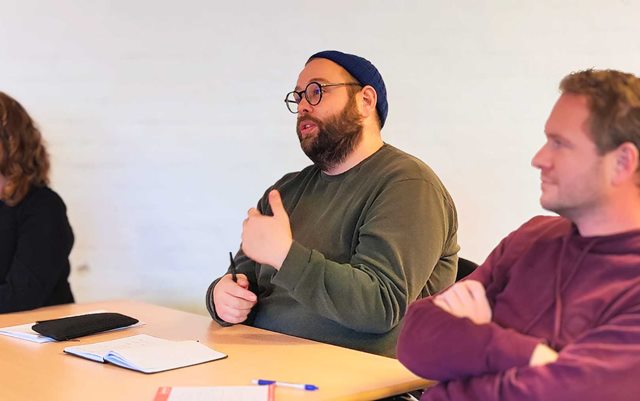 Mathias fra NØK festivalen lytter til præsentationer af studerende