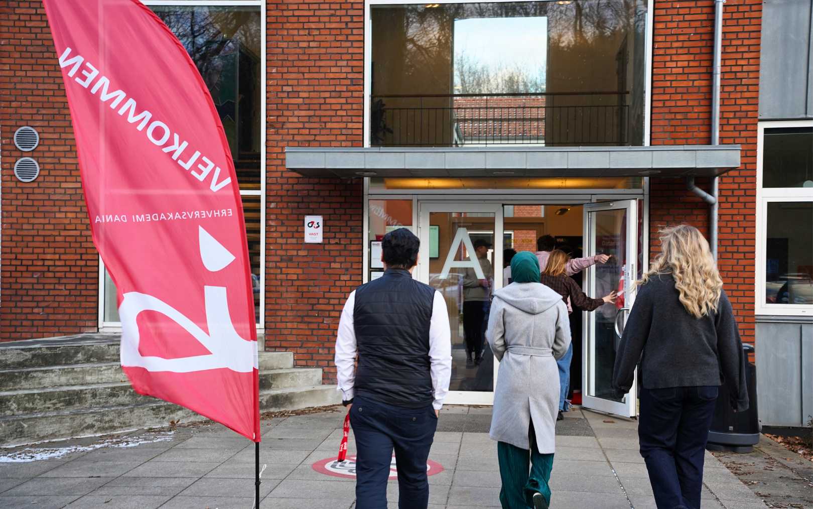 Indgangen til Danias campus på Nattergalevej set udefra - nu med mennesker