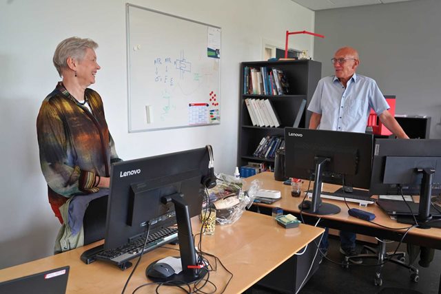 Joan og Laurids står på deres kontor sammen. De har undervist på produktionsteknolog-uddannelsen på Erhvervsakademi Dania i Randers i knap 30 år hver