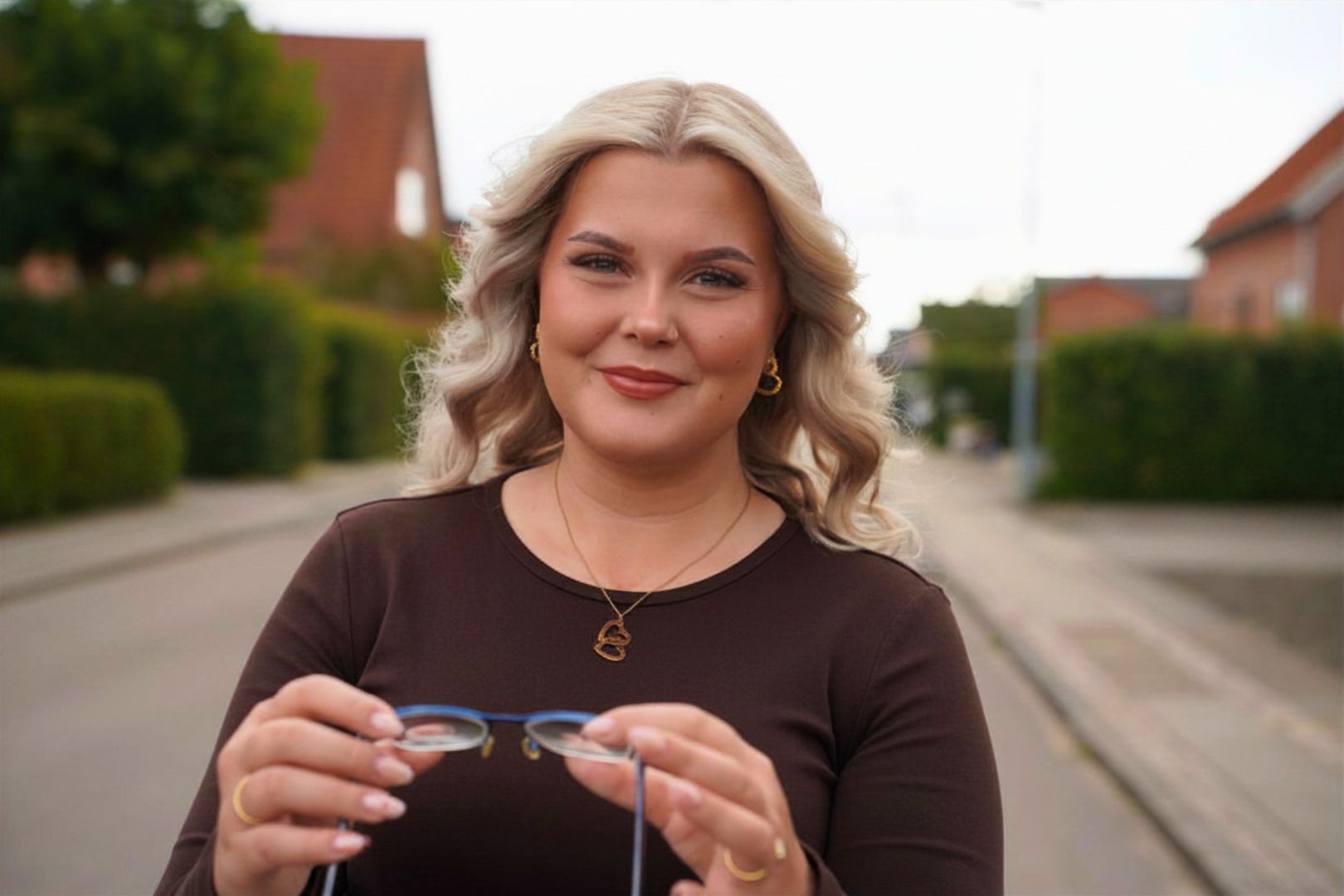 Isabella står på gaden i Holstebro og kigger dig med briller i hånden, fordi hun har søgt ind som optometrist på Erhvervsakademi Dania i Randers